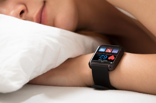 Femeie dormind cu smartwatch la mana